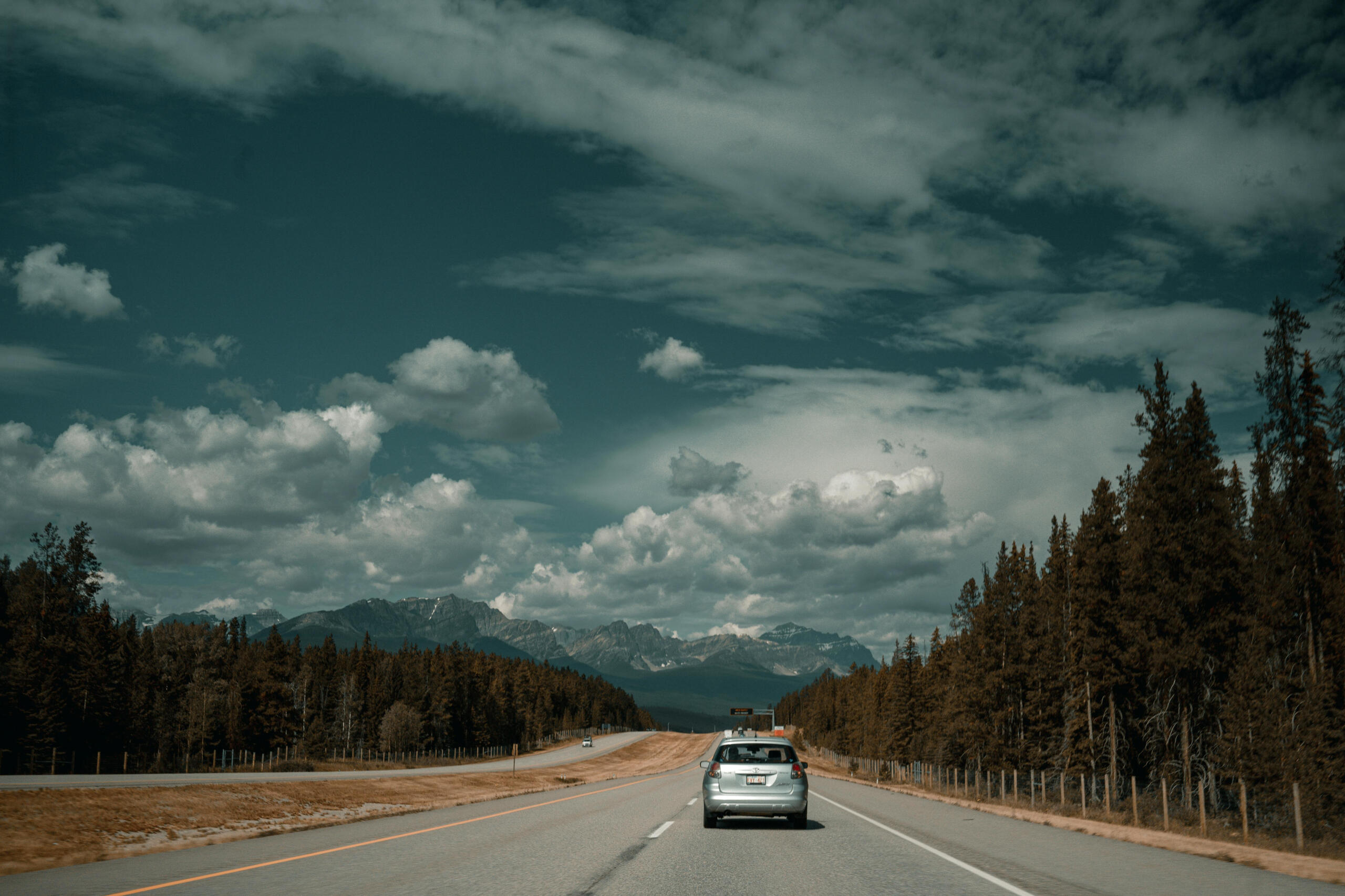 a car drives on the highway toward the mountains.