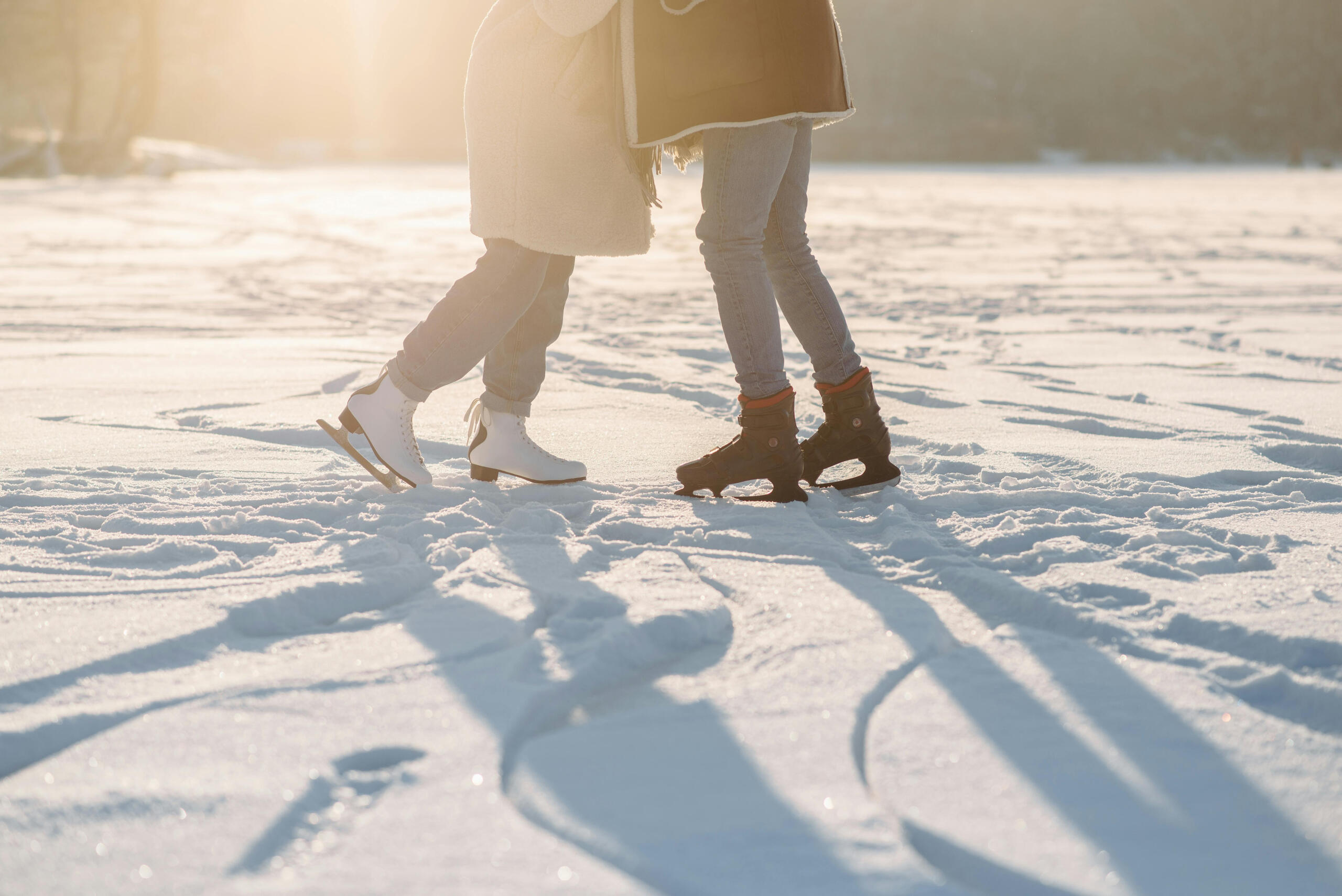 two people skate with one another, one wearing white skates and one wearing black skates.