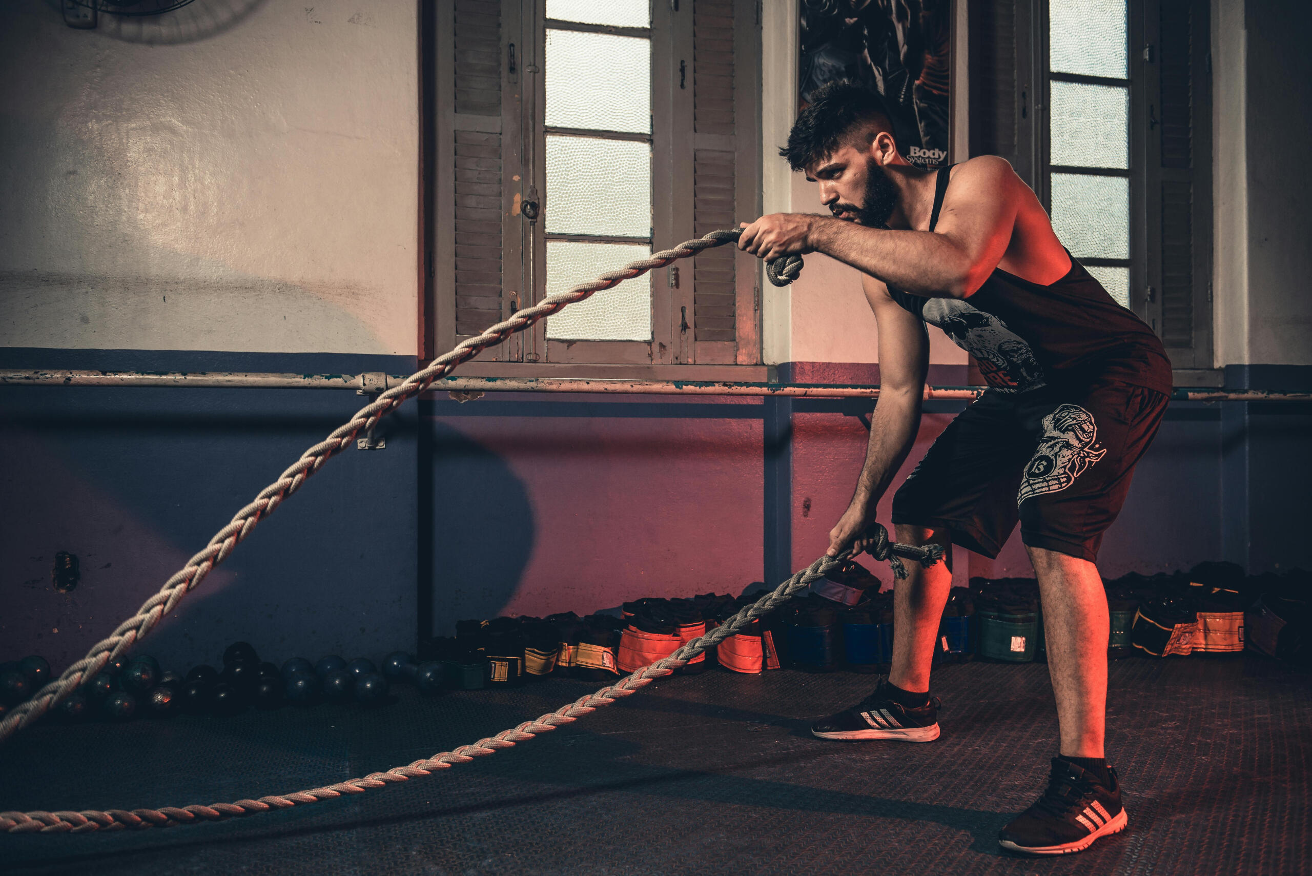 A person performing high-intensity interval training (HIIT) using ropes in a gym.