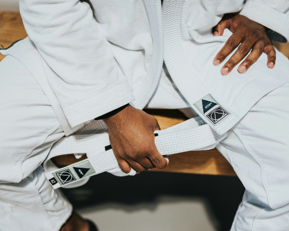 A close-up of a person tying their Brazilian Jiu-Jitsu belt before a martial arts session in Ottawa.