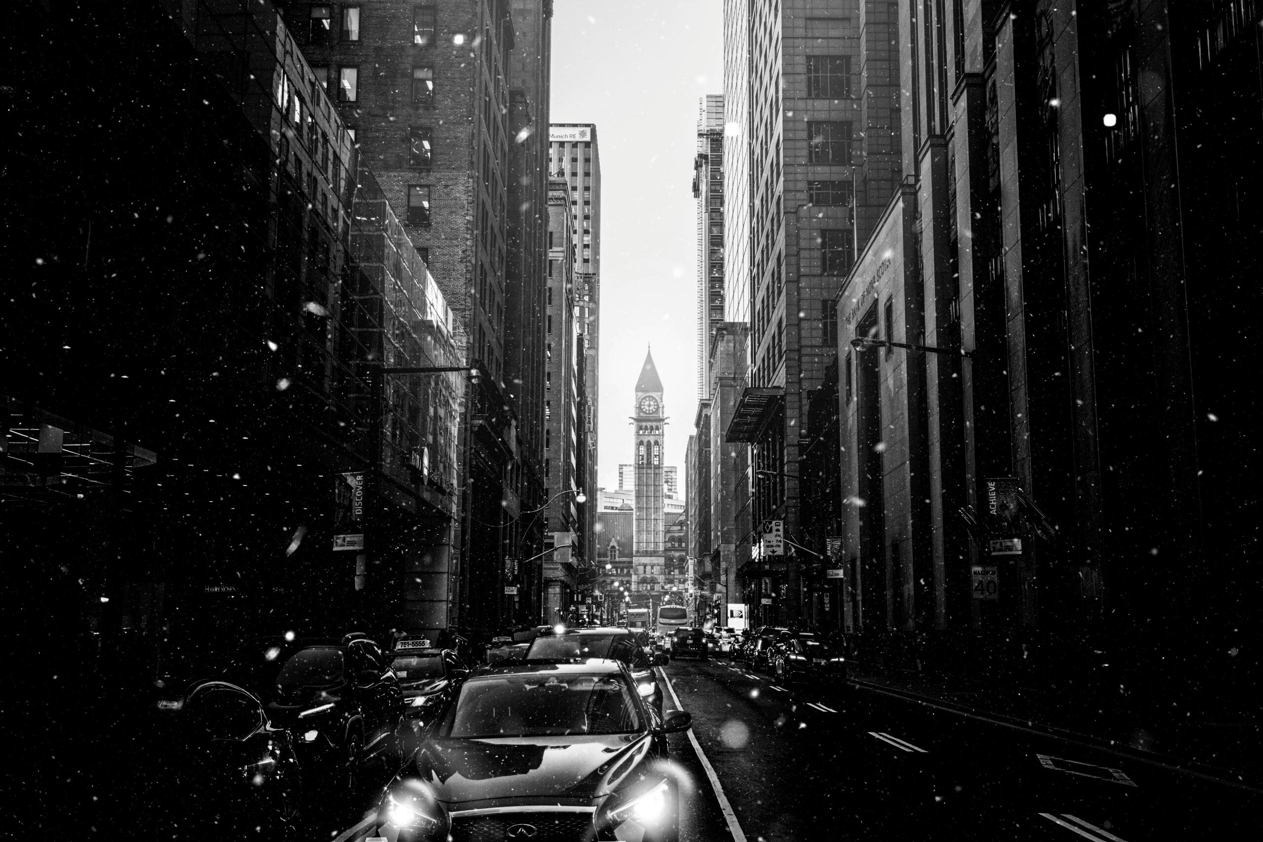 a black and white photo of downtown Toronto. A clocktower can be seen in the back.