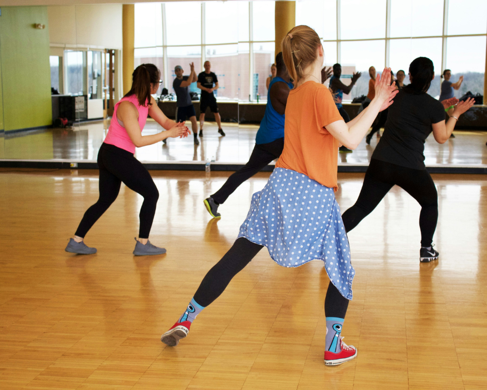 A group of people participating in a Zumba fitness class in Montreal, dancing to energetic music.