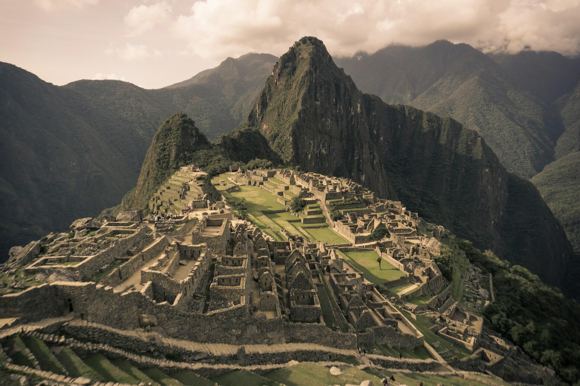 Aerial view of Machu Picchu, the ancient Inca ruins in Peru, surrounded by mountains.