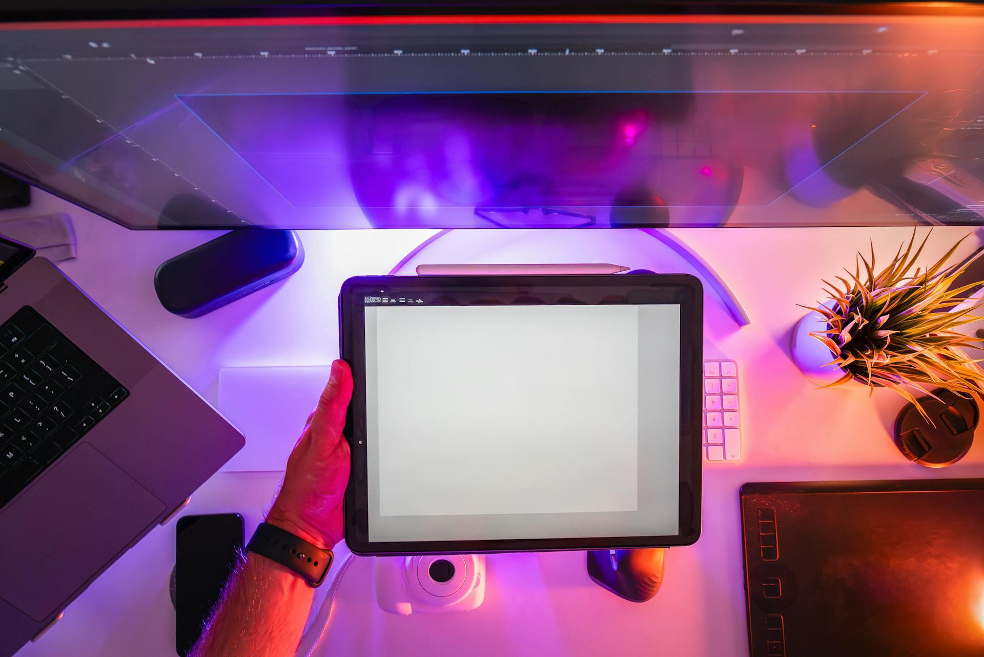 Creative Workspace with Digital Tablet and Neon Lights.