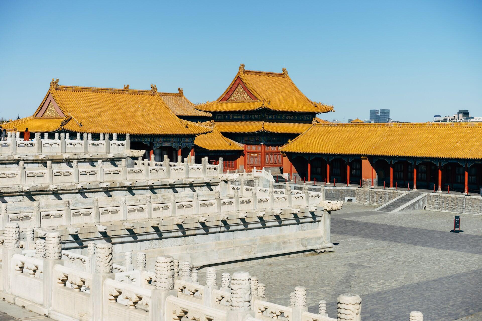 Traditional Chinese architecture with yellow roofs under blue sky.