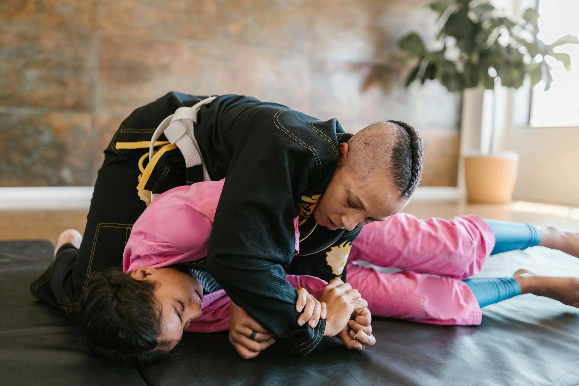 Man in Black Long Sleeve Shirt Lying on Top of Woman in Pink Long Sleeve and Pants.