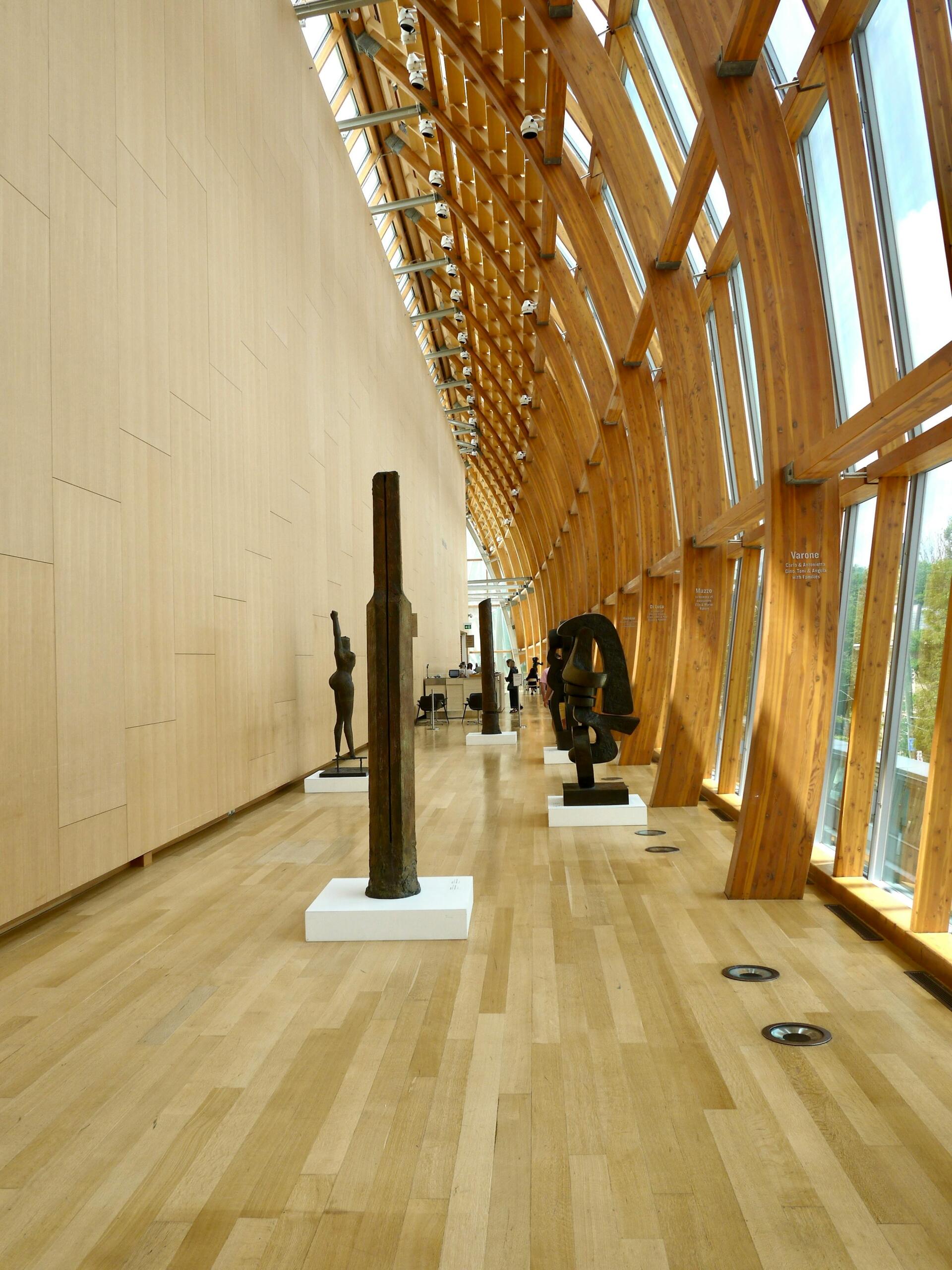 a hallway with a wooden floor and tall windows.