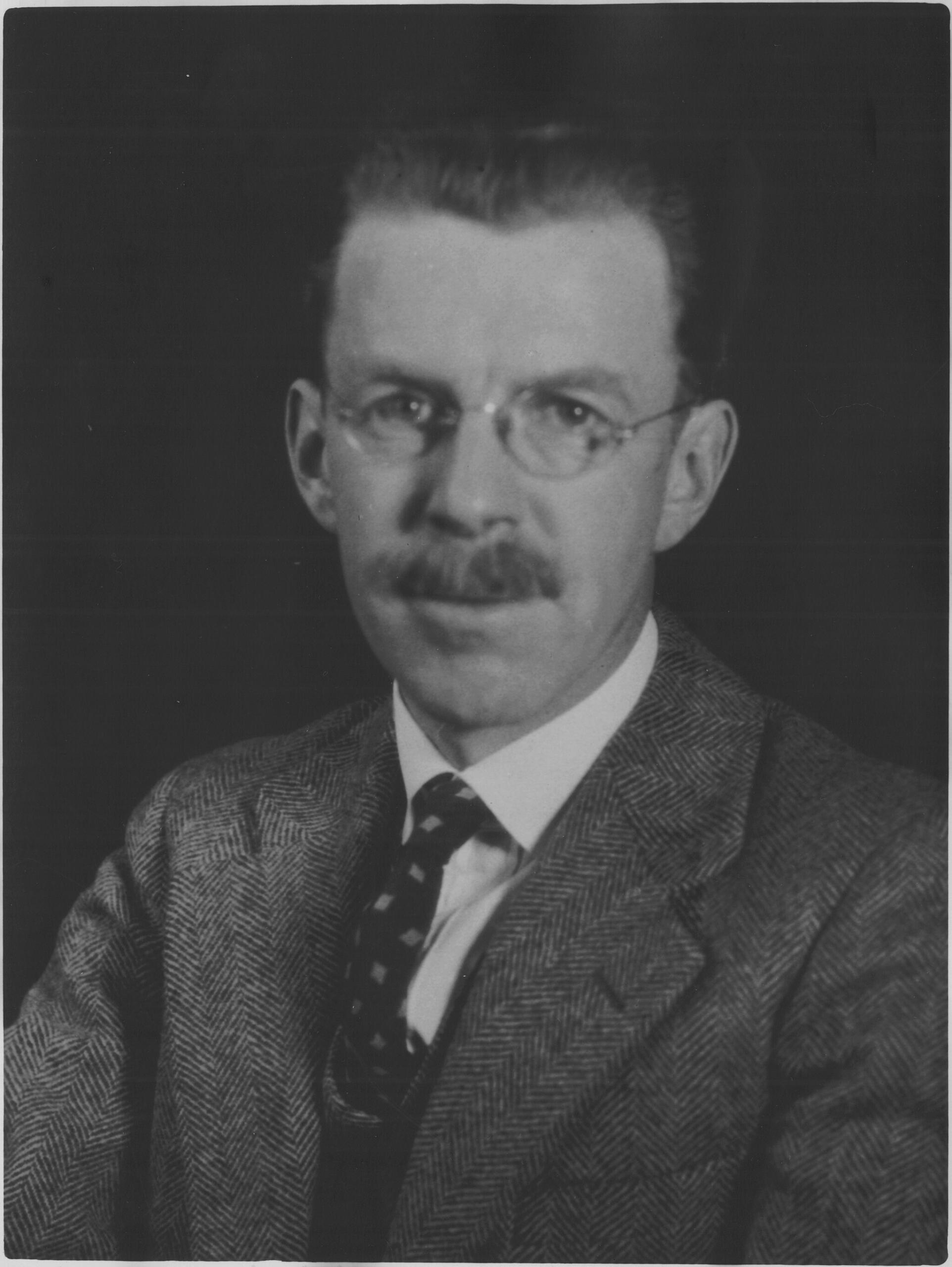 a black and white photo of a man in a tie.