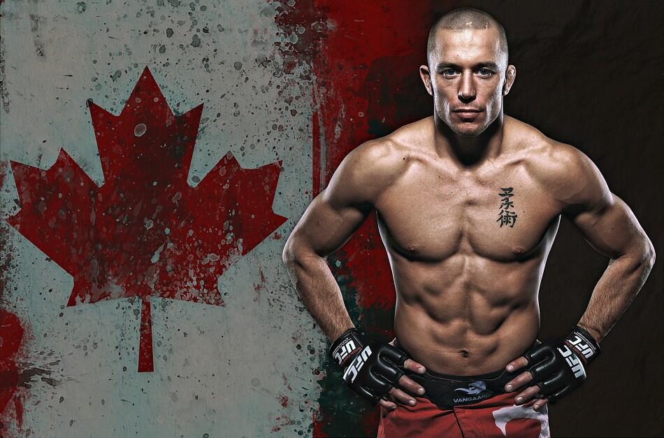 A muscular fighter stands confidently with a Canadian flag backdrop, wearing UFC gloves and showcasing a prominent tattoo.