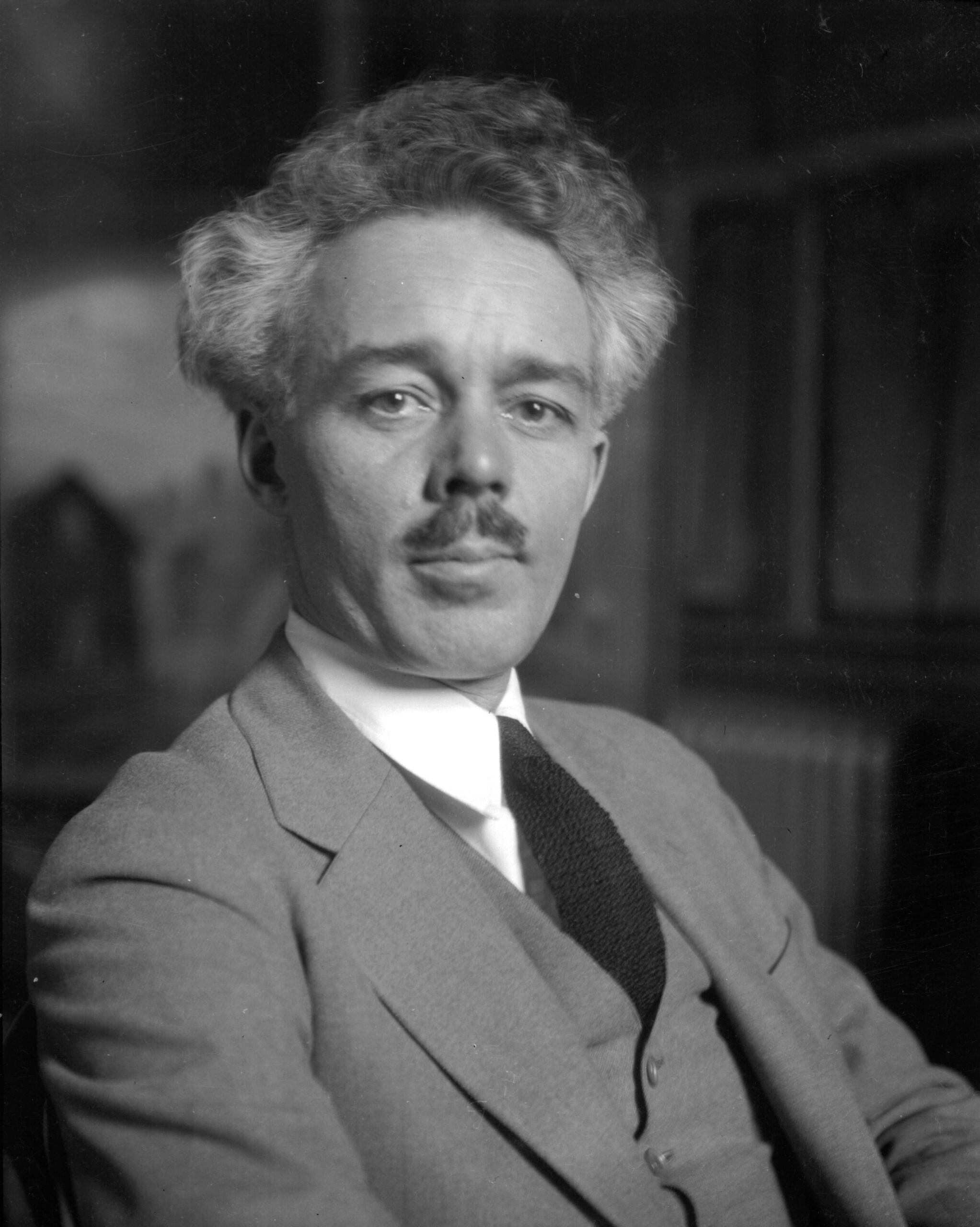 Lawren Harris pictured wearing a suit and tie. He has a mustache and graying hair.