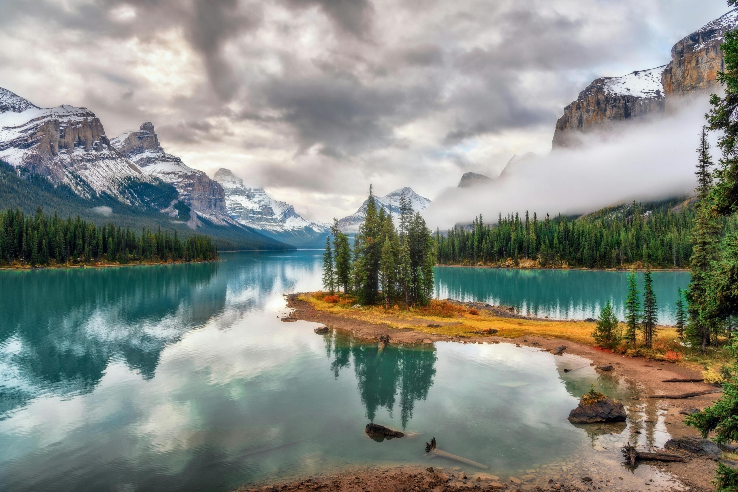 A beautiful lake surrounded by pine trees and mountains.