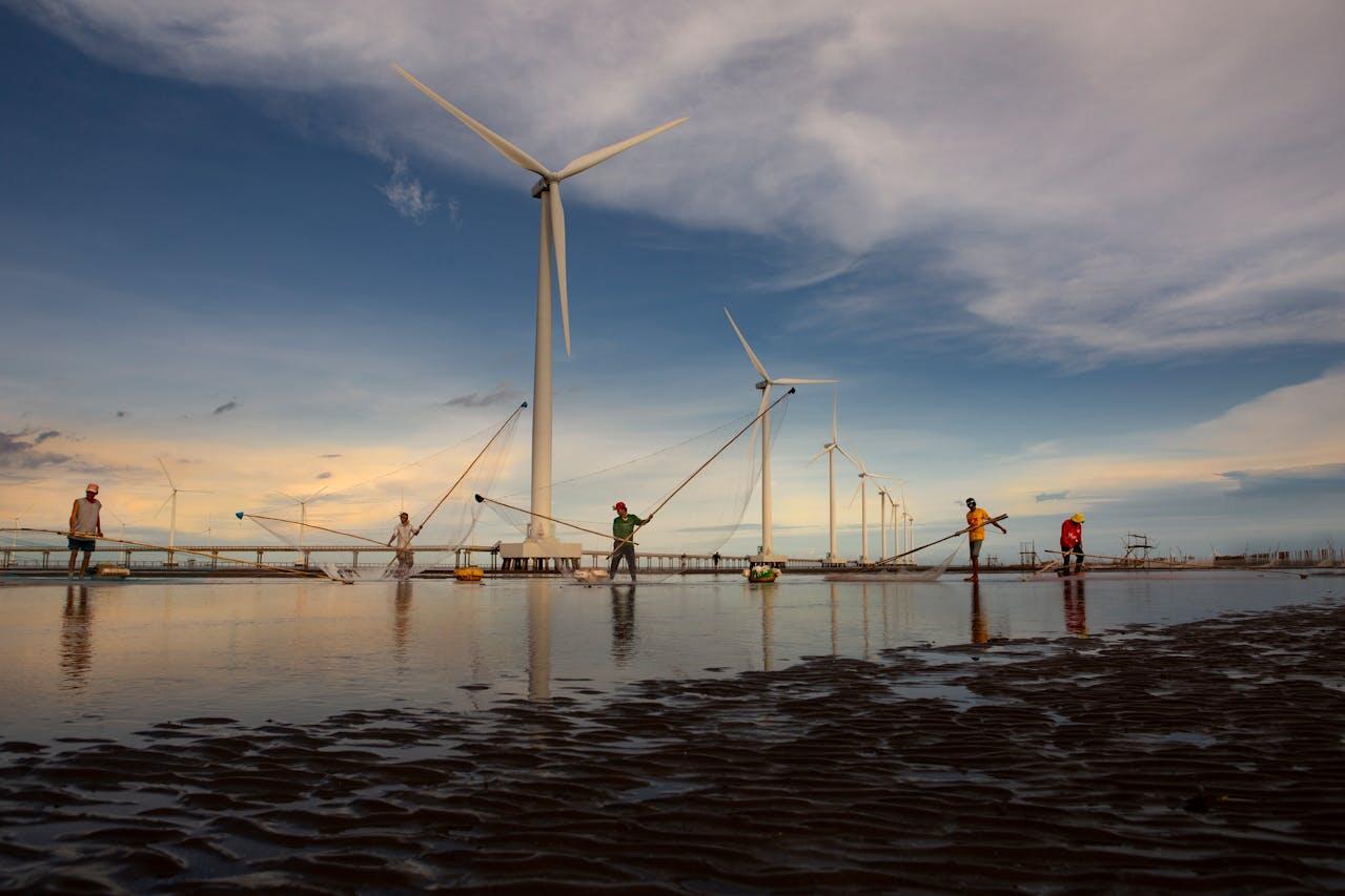 workers working around wind turbines near offshore
