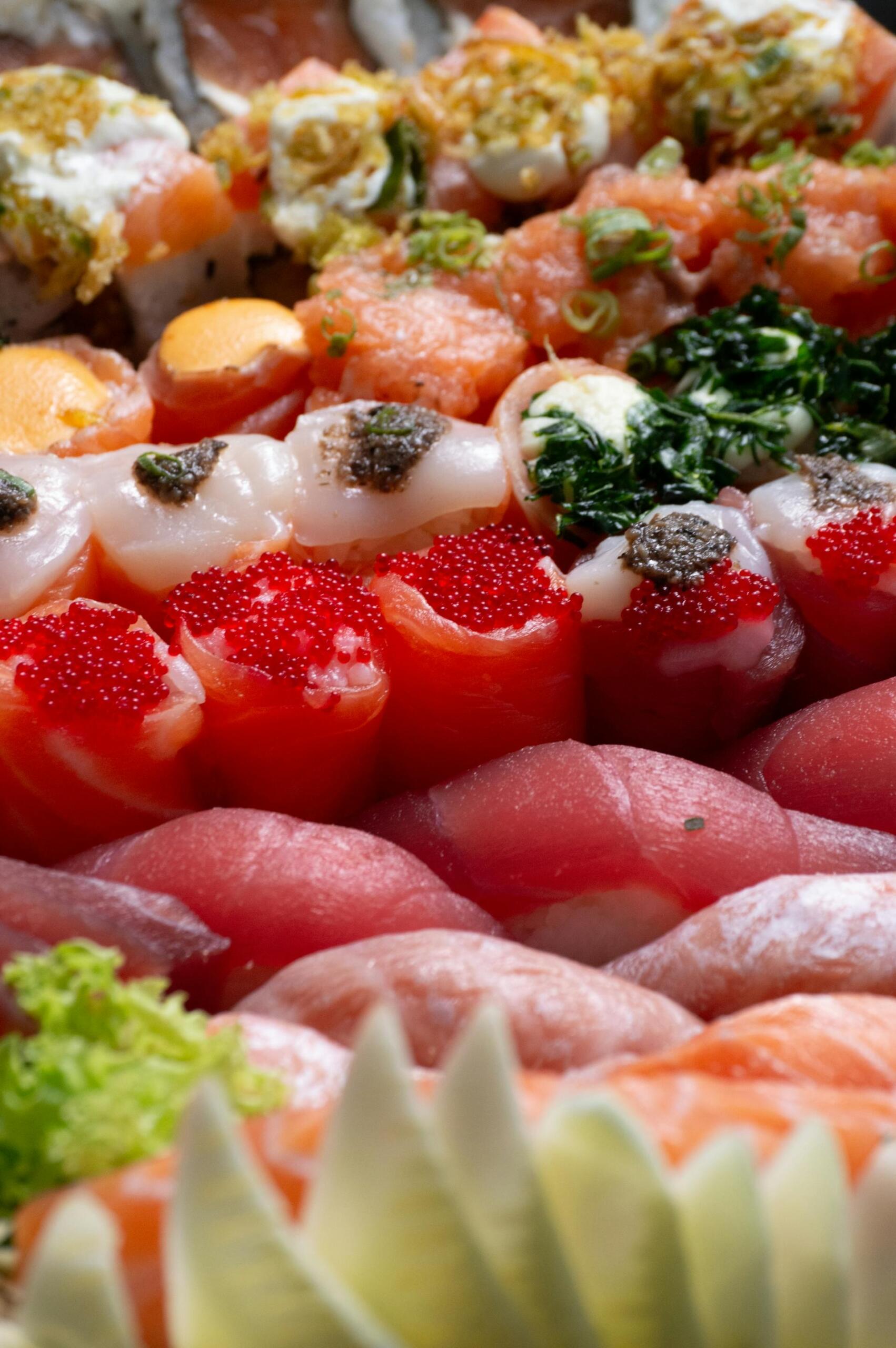A vibrant sushi platter featuring assorted nigiri, rolls with colorful toppings, and garnishes arranged in an appealing display.