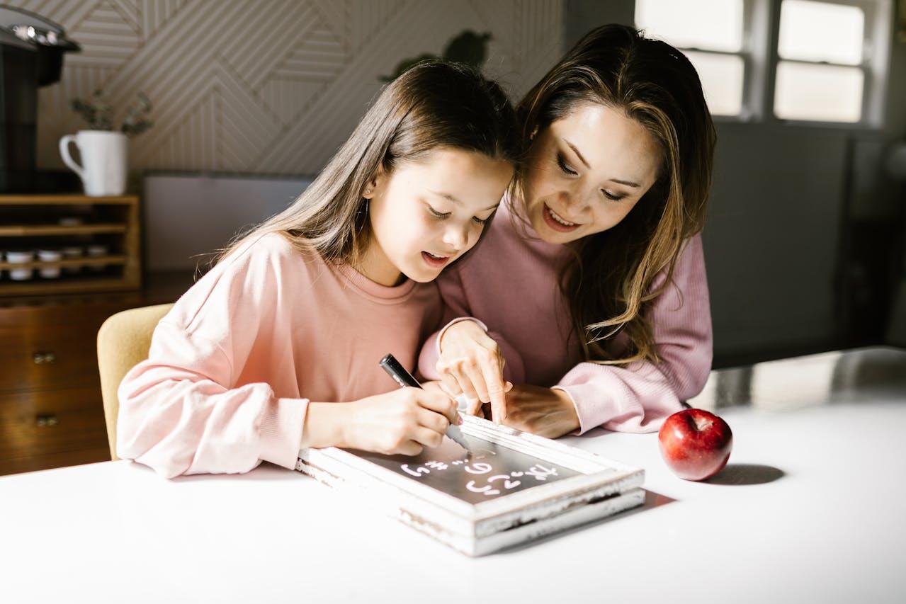 A mother writing some maths on an interactive board with daughter.
