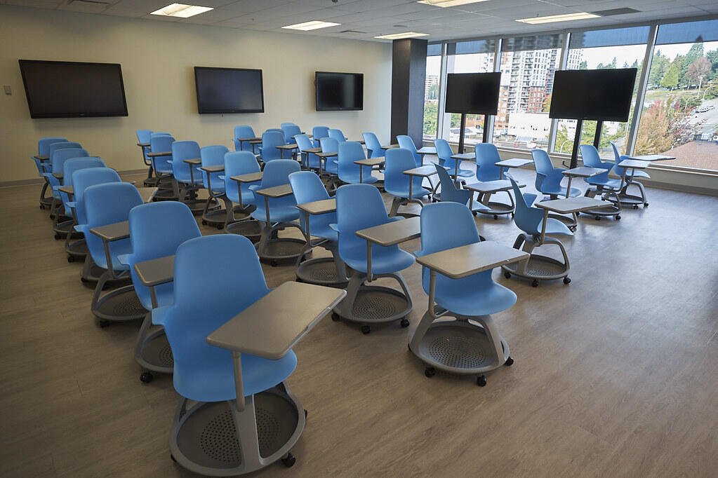 Modern classroom with blue chairs and large screens at Douglas College, ready for students studying marine biology.