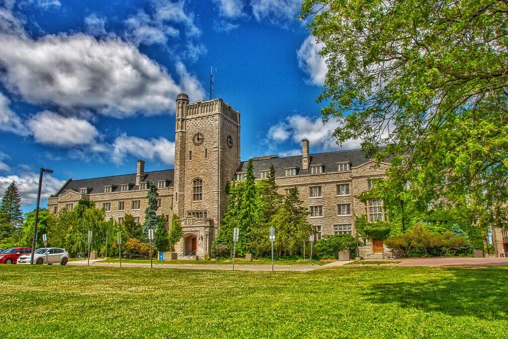 University of Guelph campus in Ontario, featuring a historic building surrounded by trees and green lawns.