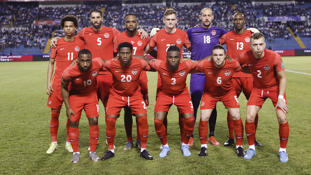 Canada men’s national soccer team posing for a pre-match photo in red uniforms during a FIFA World Cup qualifier.