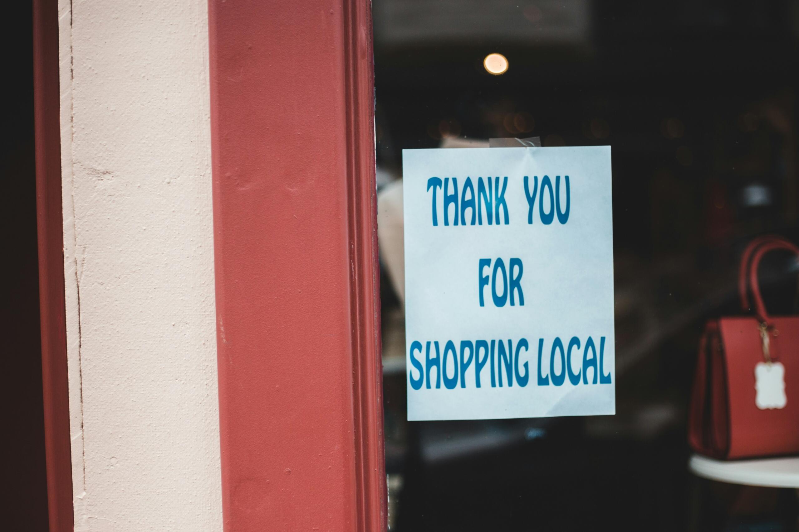 Storefront window with a sign saying ‘Thank You for Shopping Local’