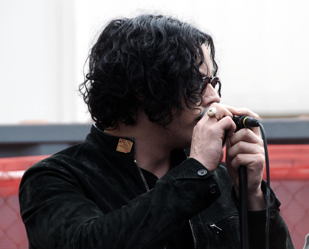Jack White on stage holding microphone