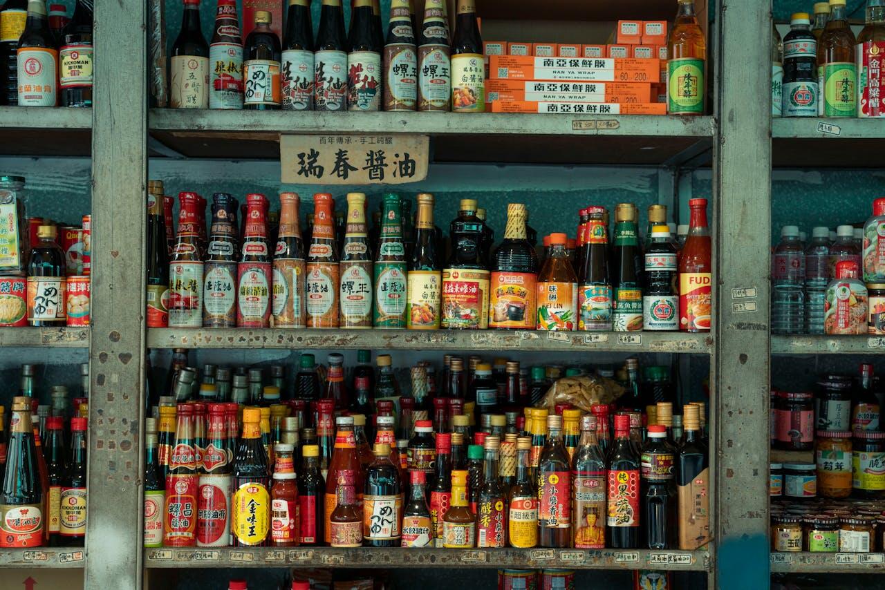 A wooden shelf filled with various Asian sauces and condiments, featuring colorful bottles and a sign in Chinese characters.