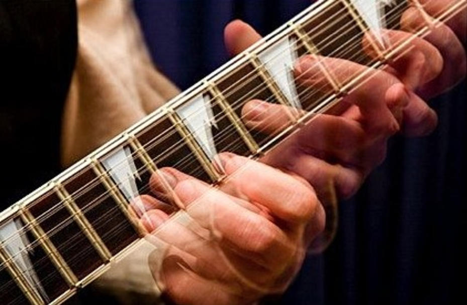 A man plays guitar really quickly.