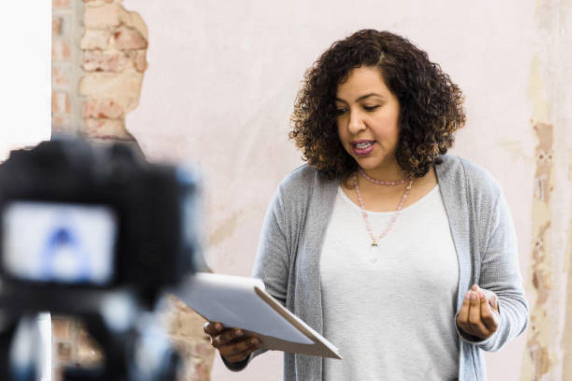 A woman stands before a camera to audition for a commercial.