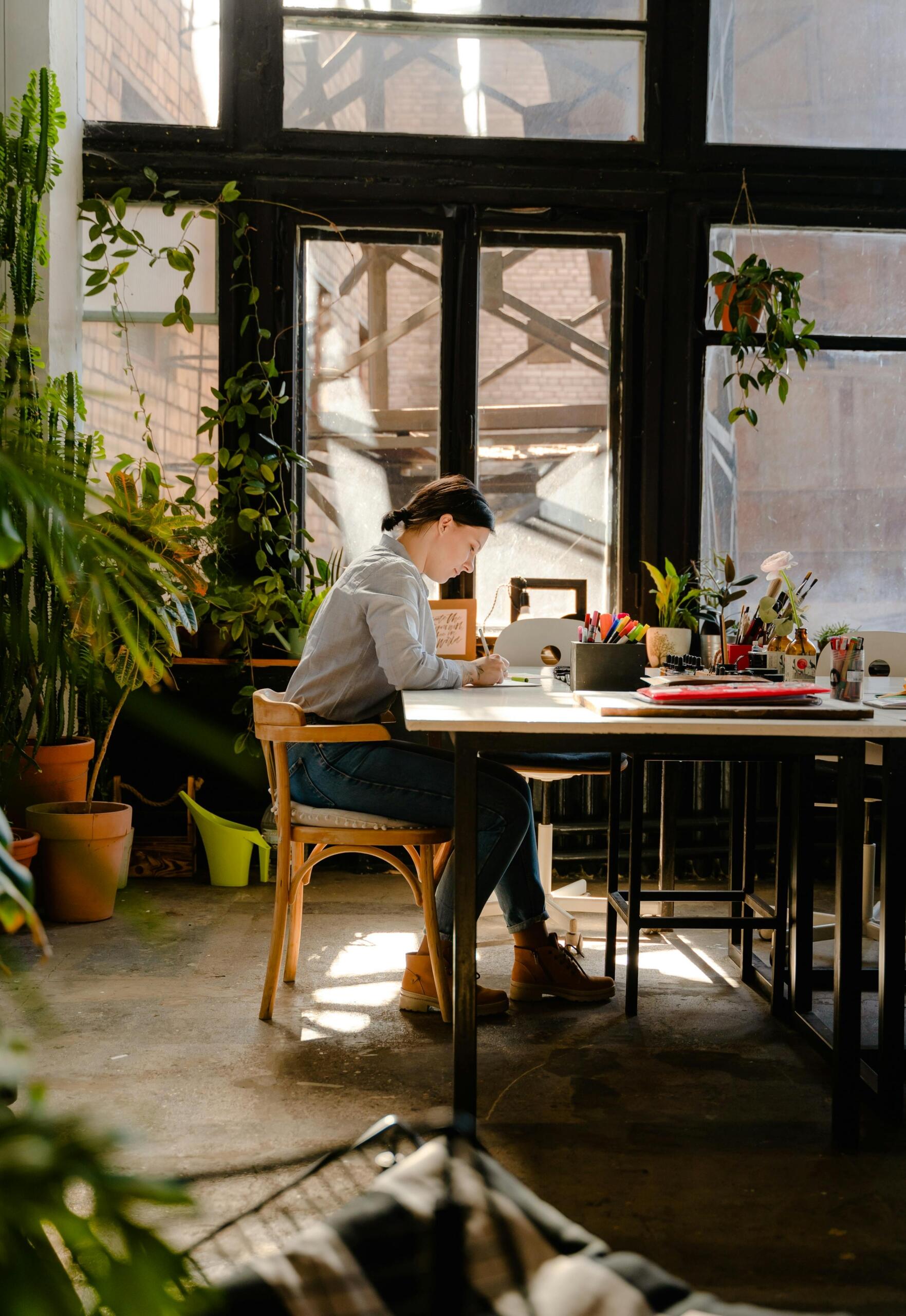 Woman sitting by the table while writing
