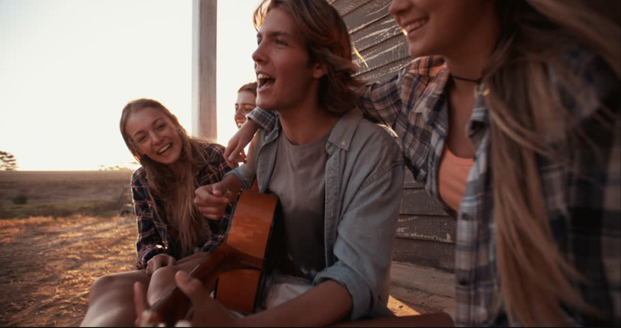 A man plays guitar with friends.
