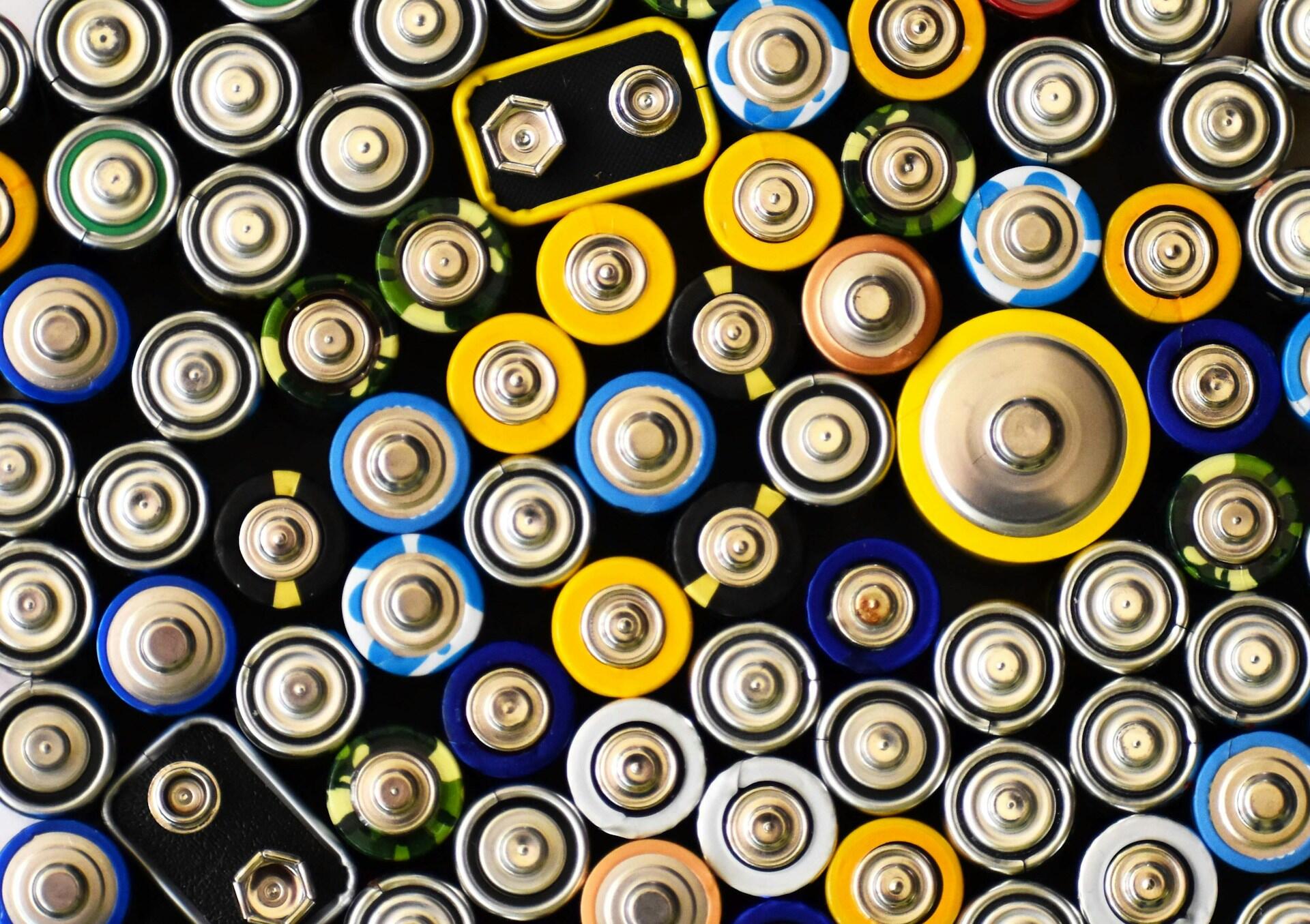 A vibrant assortment of batteries in various colors and sizes, displaying their metallic tops and distinctive designs.