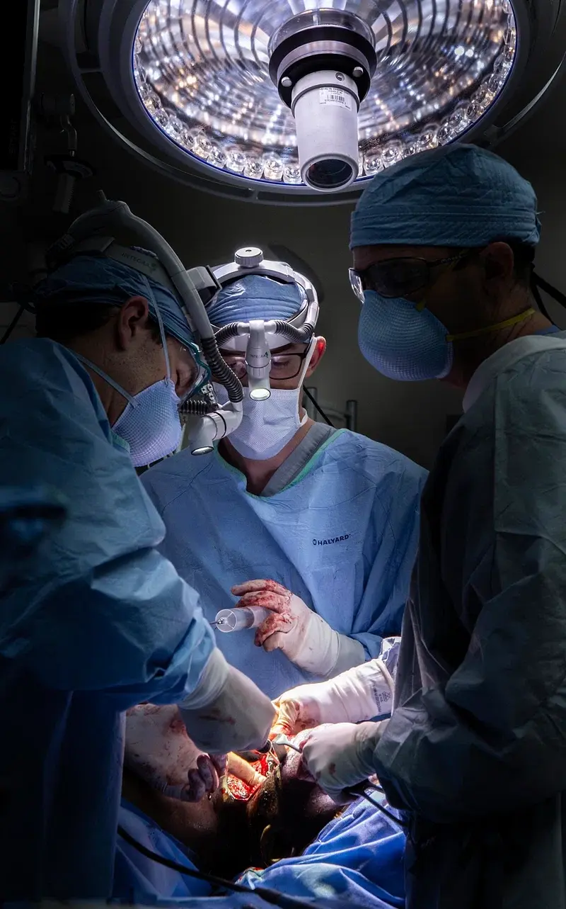 Surgeons performing an operation under surgical lights.