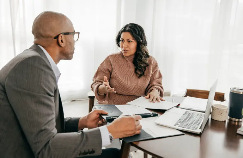 Two professionals sitting at a table engaged in a one-on-one interview or admissions discussion.