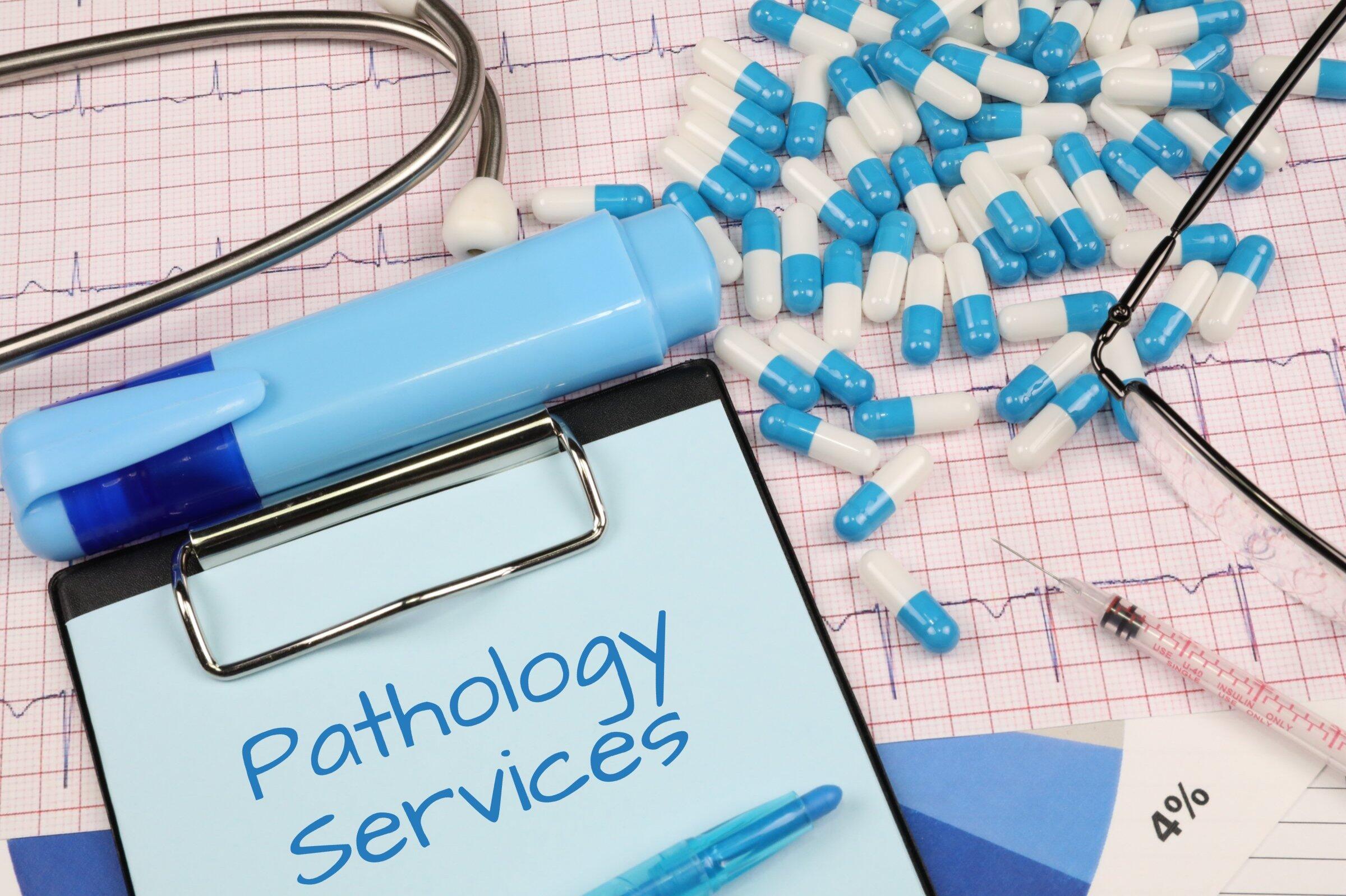 Pathology services concept with clipboard, capsules, and stethoscope.