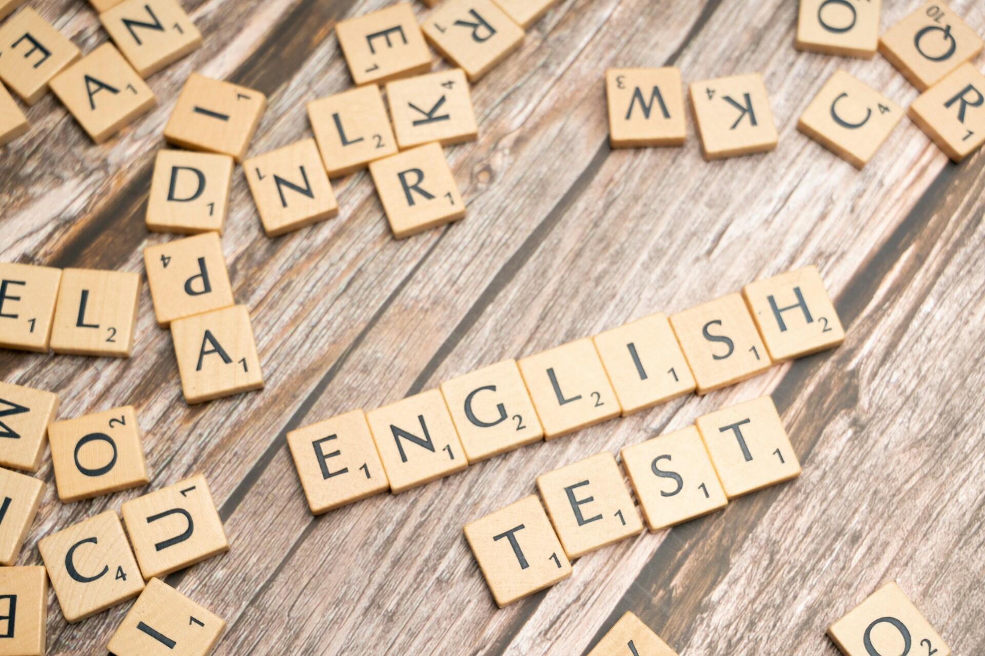 Wooden Scrabble tiles scattered on a tabletop, with the words 