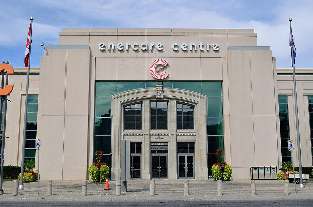 Front view of the Enercare Centre, featuring large glass doors, decorative plant pots, and the venue's name prominently displayed above.
