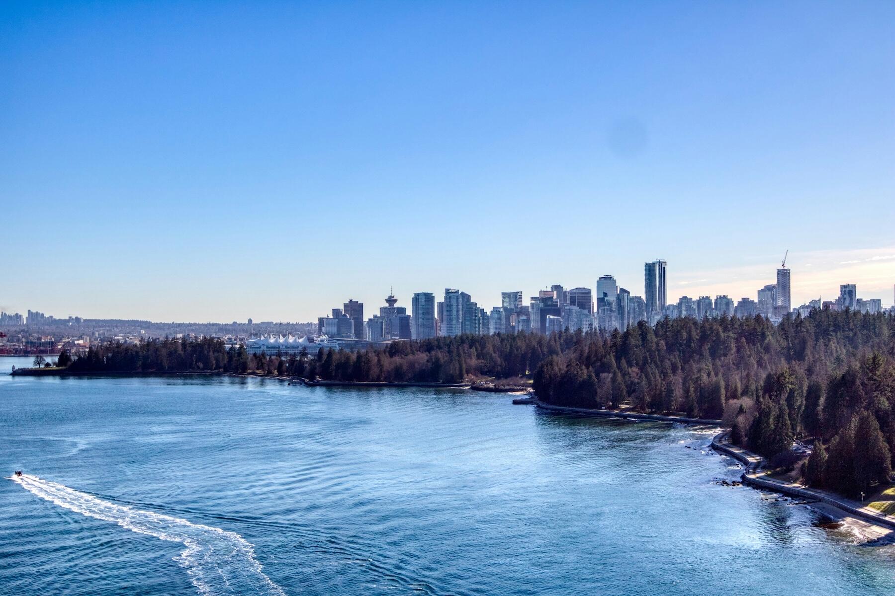 A boat navigates the water, framed by a bustling cityscape nearby. 
