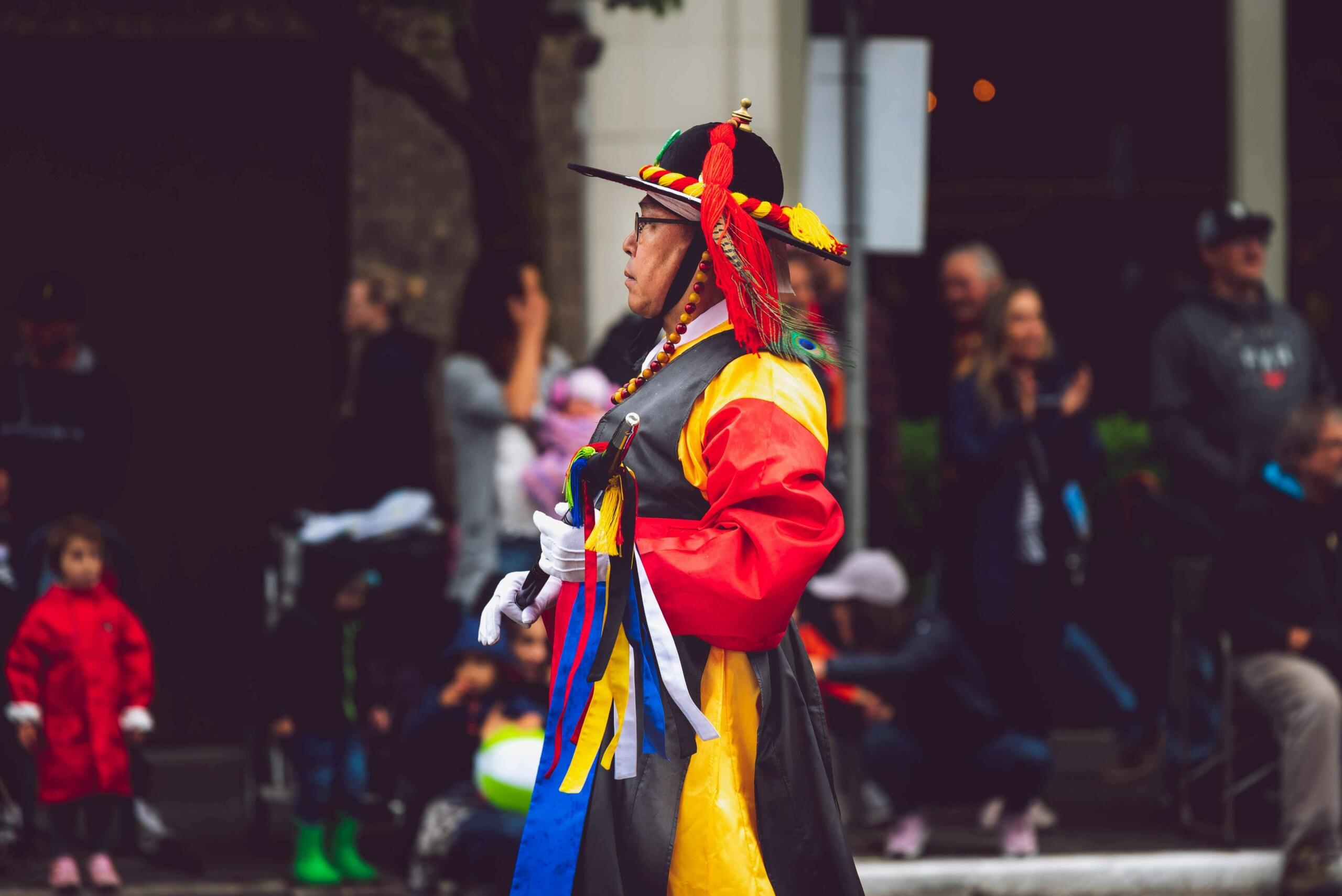 Person wearing traditional Korean clothing (hanbok), standing during a cultural celebration.