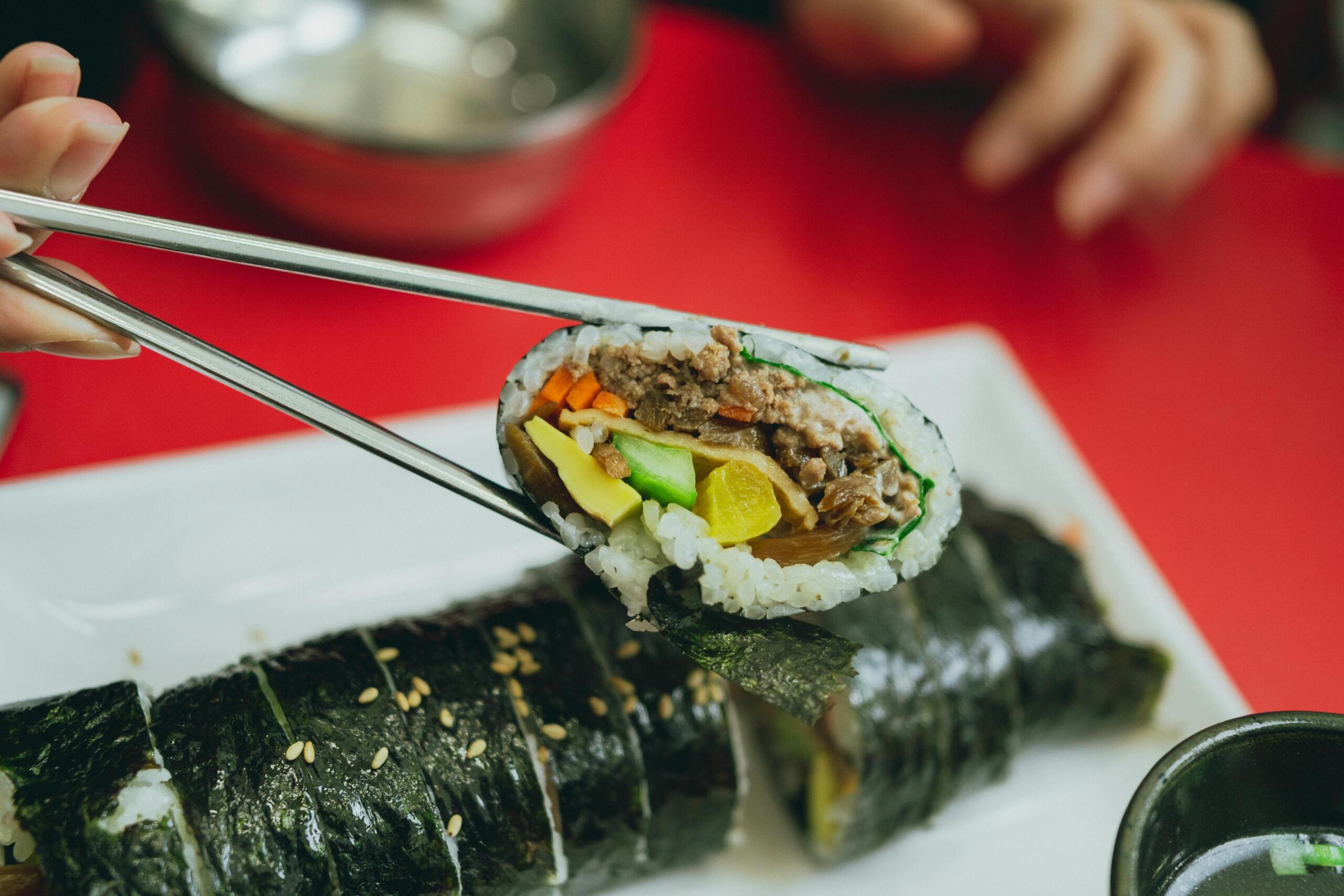 Kimbap rolls sliced and arranged neatly, showing rice, vegetables, and fillings in a traditional Korean dish.