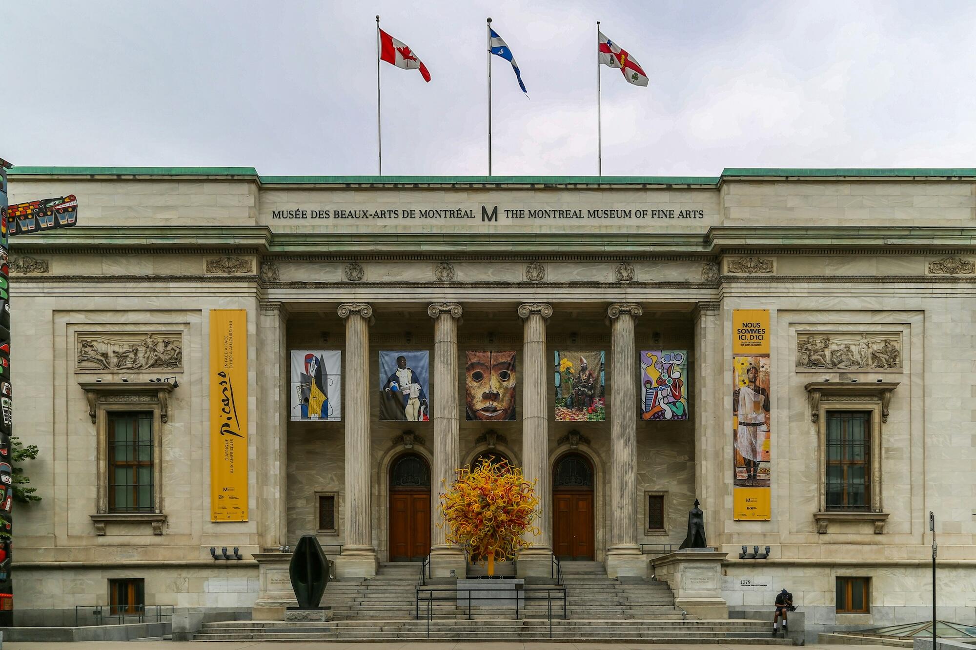 A large building featuring a prominent front entrance supported by tall columns.