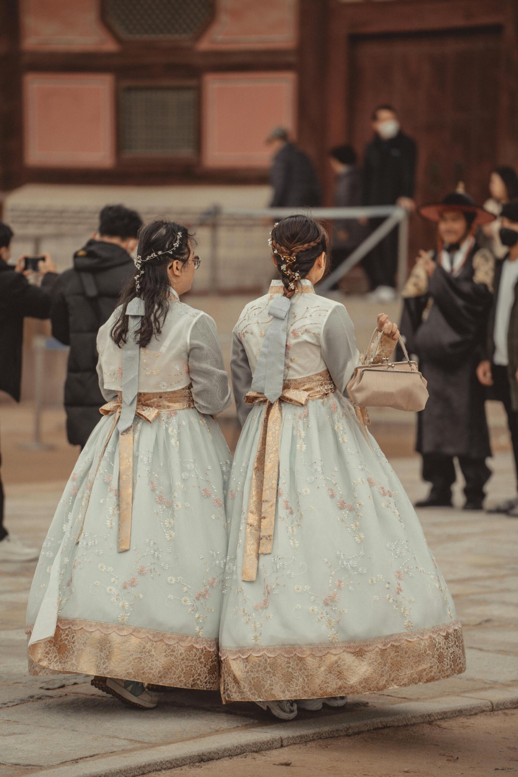 Two Korean women wearing traditional attire (hanbok), standing together during a cultural celebration. Source: Line Knipst.