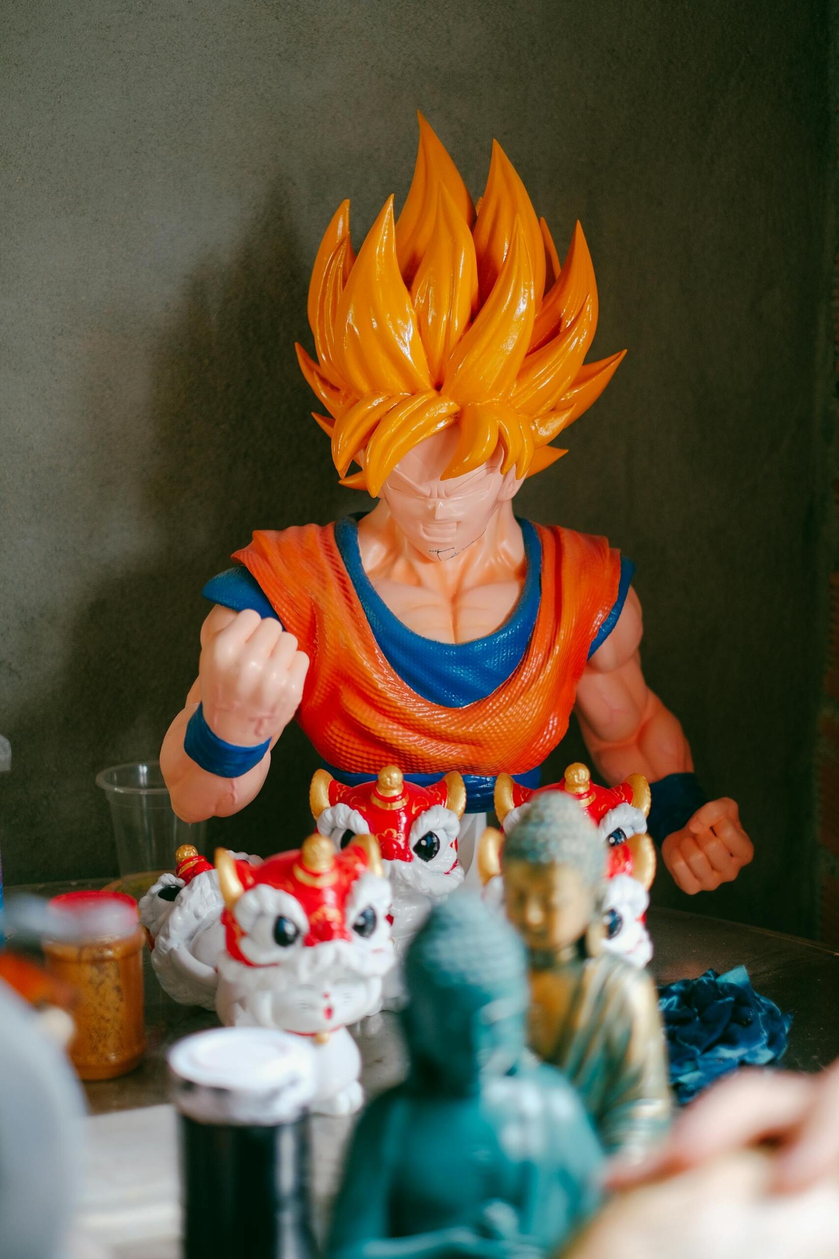 Plastic Super Saiyan Goku figurine with bright orange spiky hair and clenched fists displayed on a table among small decorative statues and dragon figures.