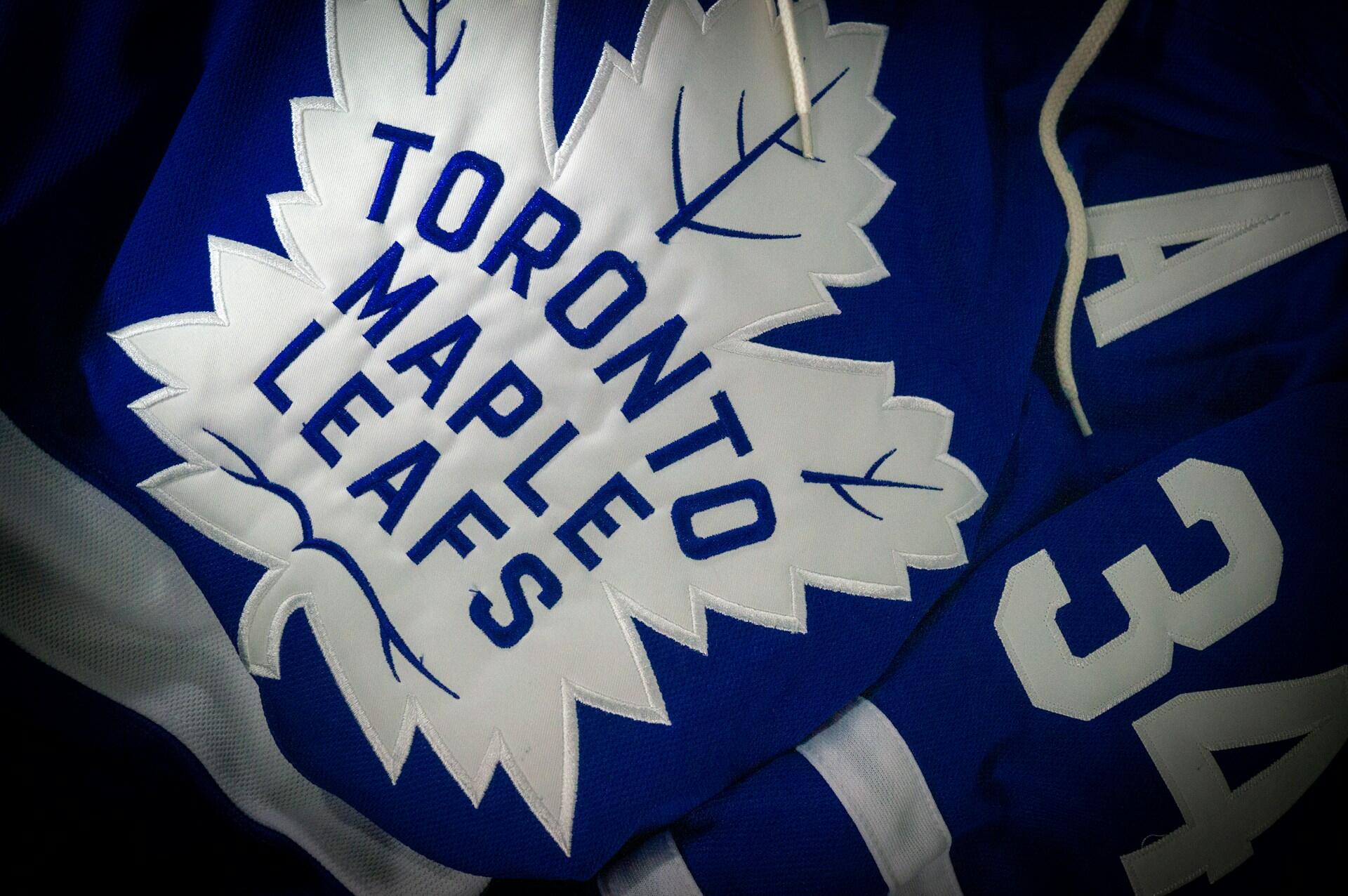 Blue hockey jersey showcasing the Toronto Maple Leafs logo and the number 34, prominently displayed on a textured fabric background.