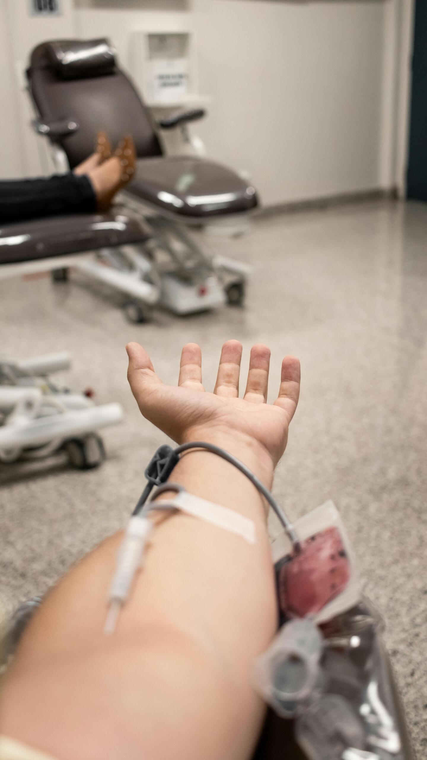 Person’s arm with an intravenous (IV) line inserted, connected to a medical drip during treatment