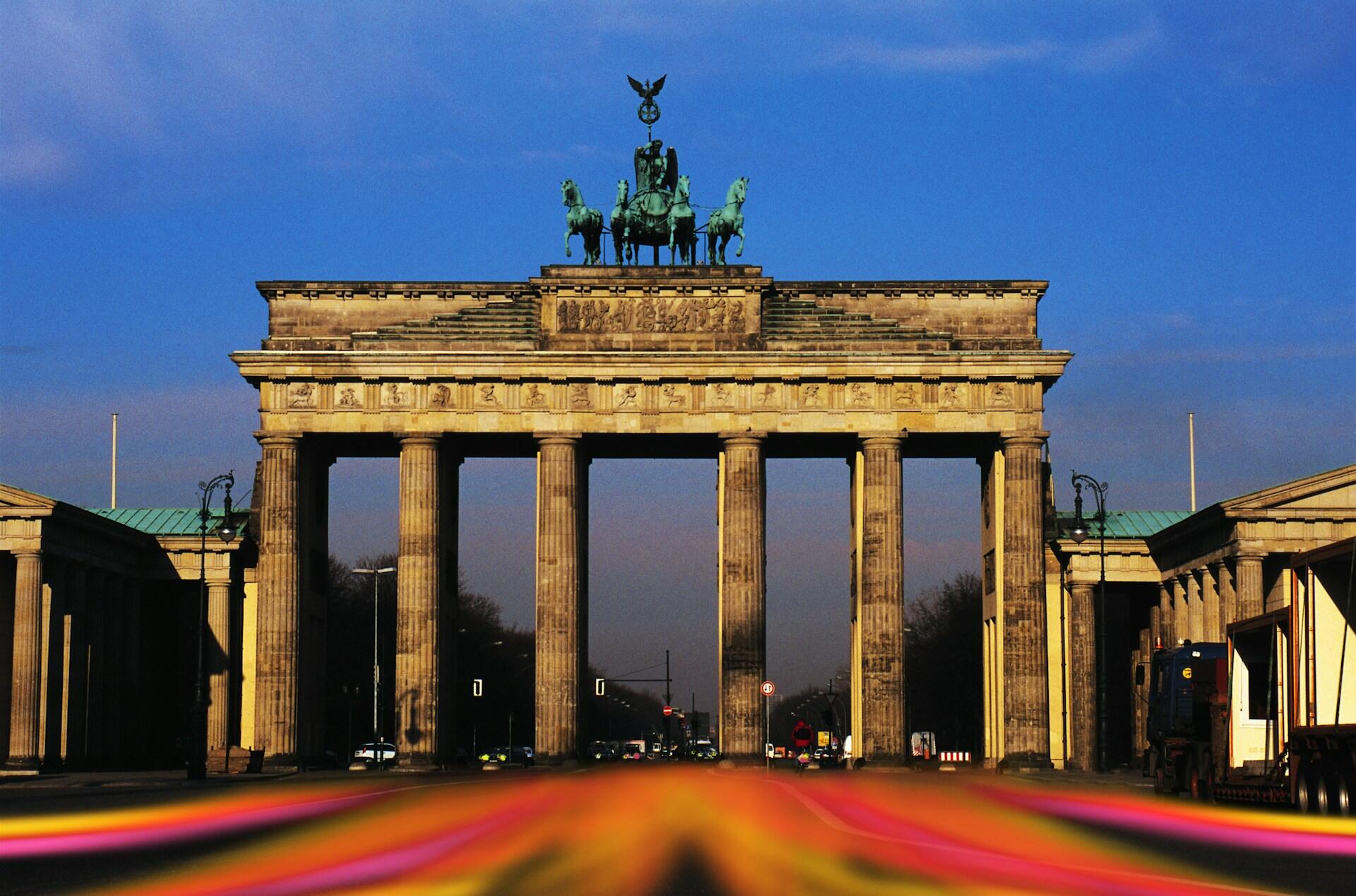 Brandenburg Gate in Berlin, a neoclassical monument with six tall columns and a chariot statue on top, under a clear blue sky.