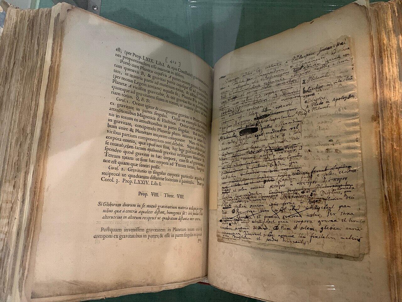 Open ancient book showing printed Latin text on the left page and a handwritten manuscript with notes and corrections on the right page.