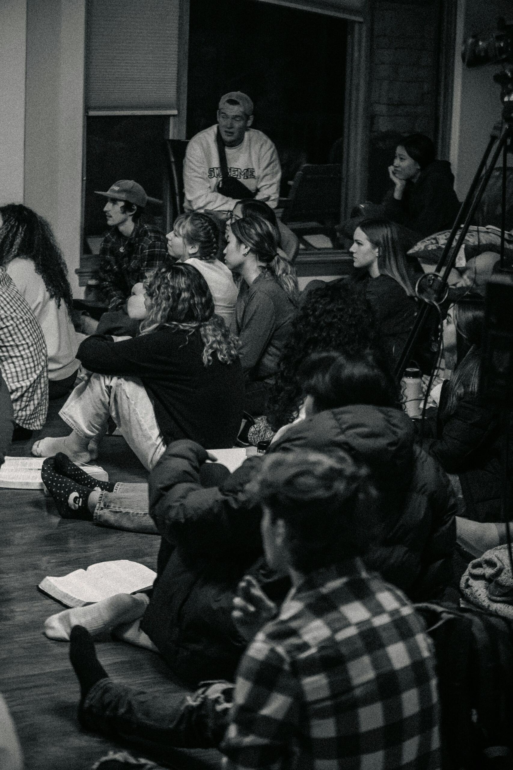 Black and white image of a group of people listening and learning.