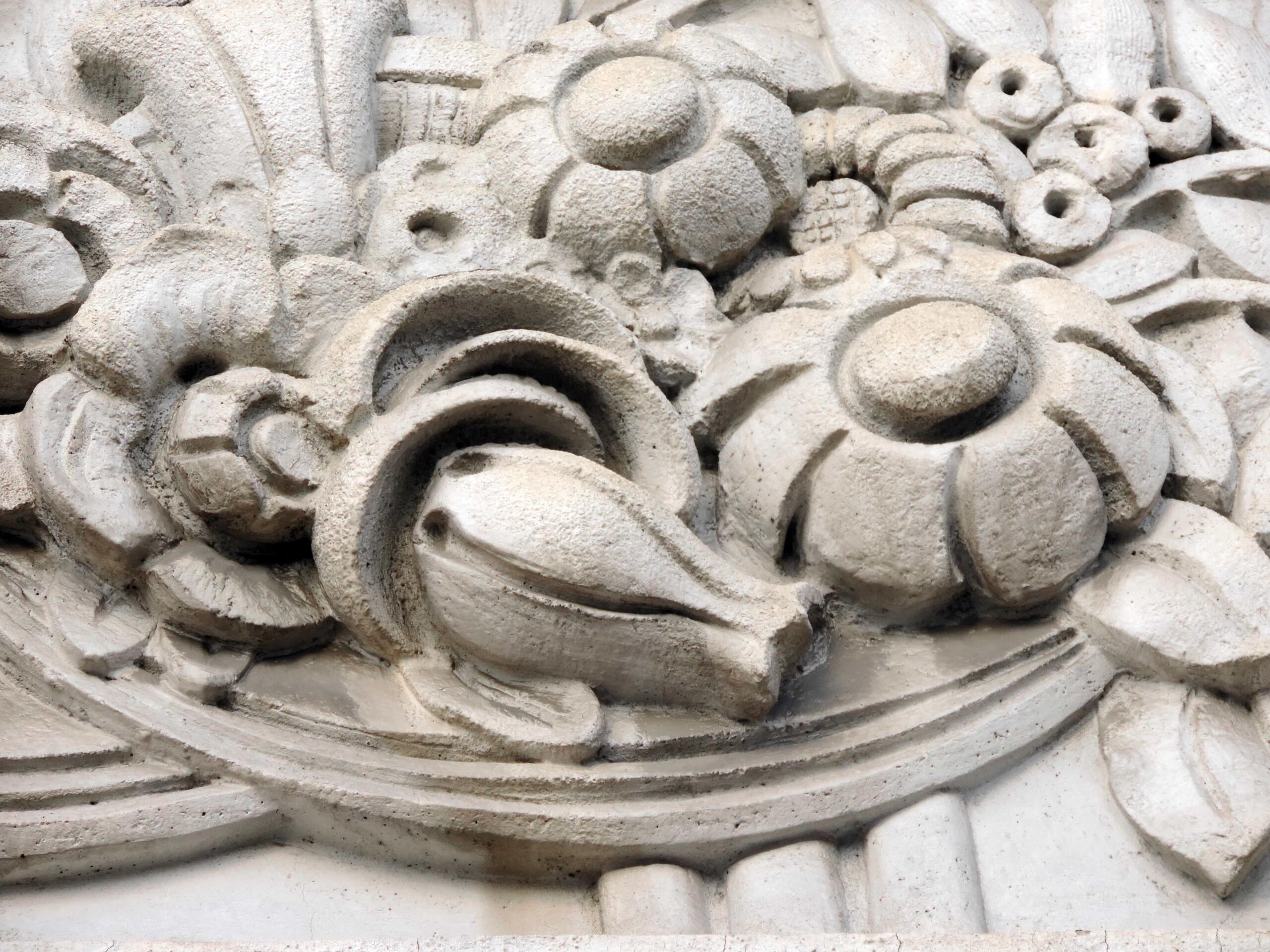 Intricate Baroque stone carving featuring floral and fruit motifs in high relief.