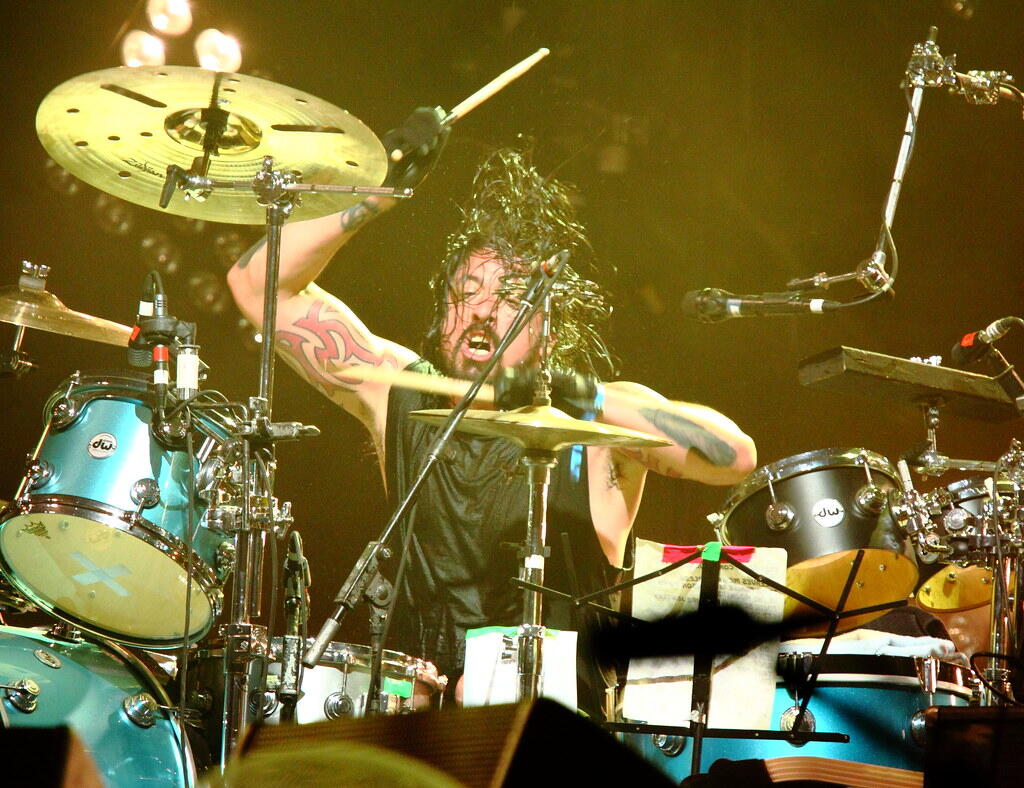 Dave Grohl passionately playing the drums during a live rock concert with Them Crooked Vultures.