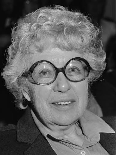 Portrait of Annie M.G. Schmidt, acclaimed Dutch children's author, smiling and wearing her signature round glasses.