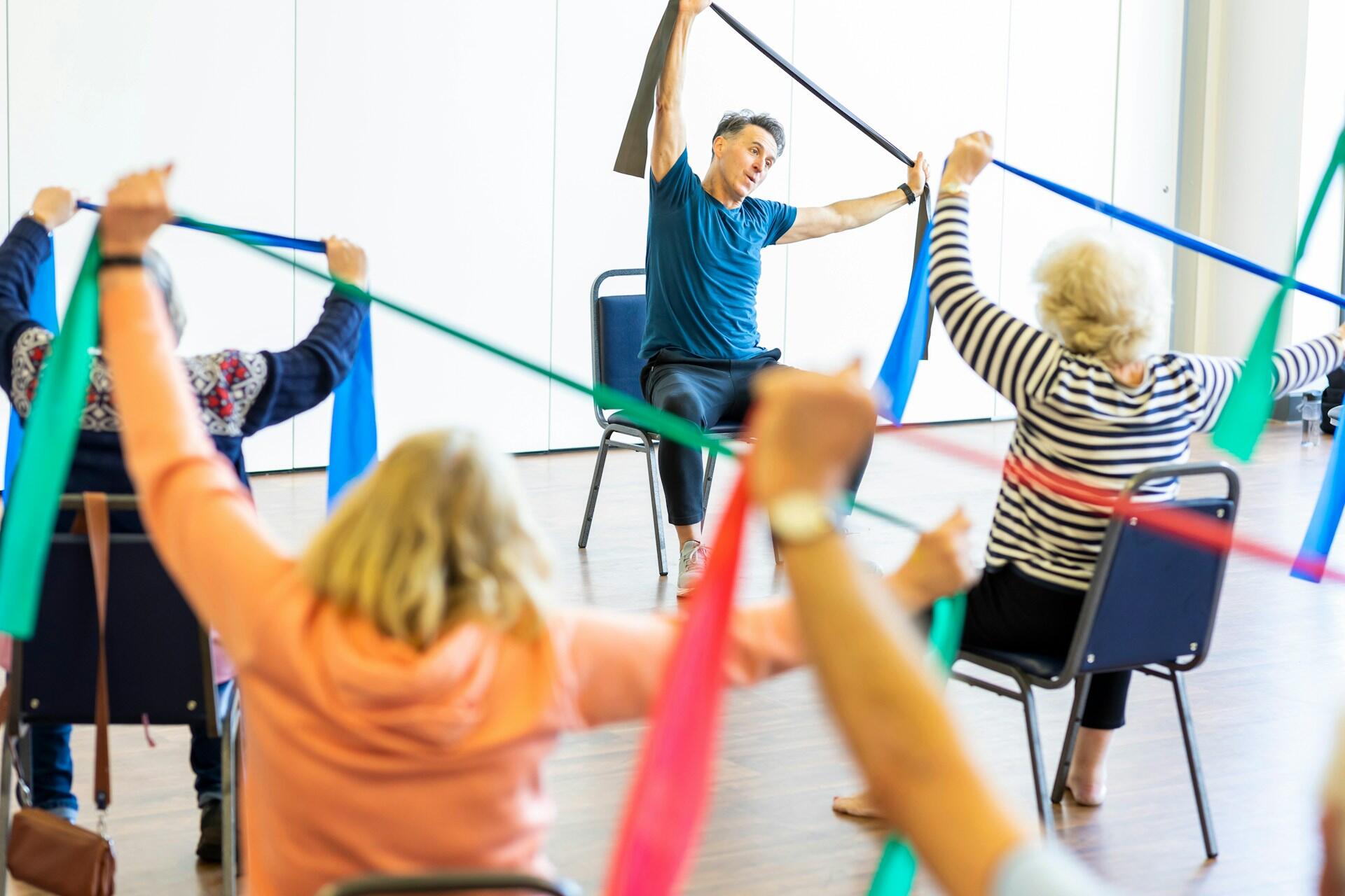 A group of individuals practicing yoga in a spacious room, focusing on various poses and maintaining balance.