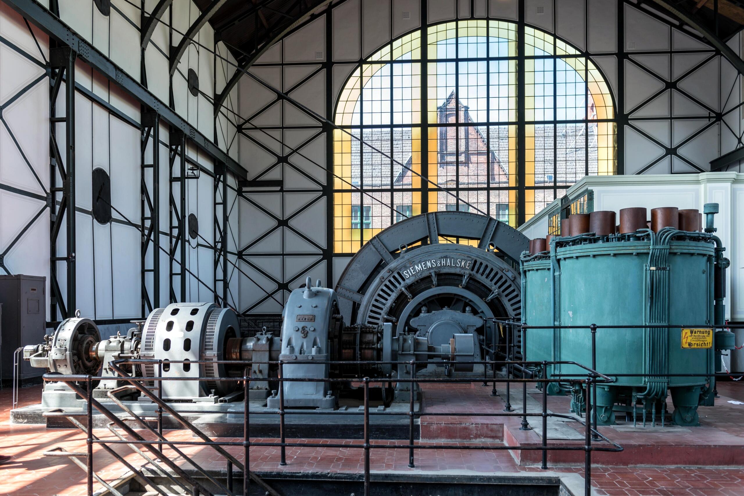 An electric generator with visible mechanical and electrical components used to convert mechanical energy into electrical energy through electromagnetic induction.
